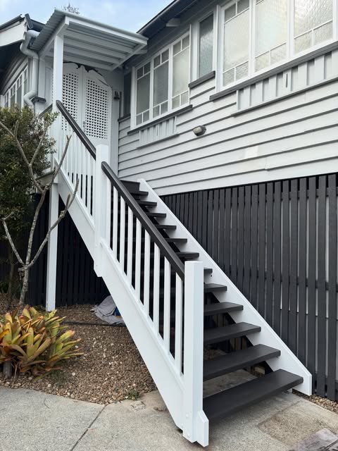 Queenslander with a newly built painted timber staircase and battened screening